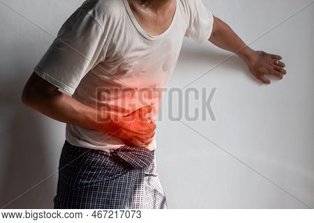 Asian Young Man Suffering From Upper Abdominal Pain. It Can Be Caused By Stomach Ache, Enteritis, Co