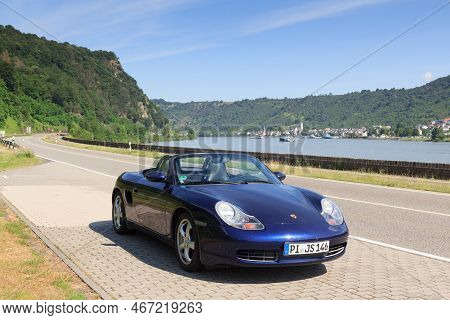 Bad Salzig, Germany - June 26, 2021: Blue Roadster Porsche Boxster 986 With River Rhine Gorge Panora