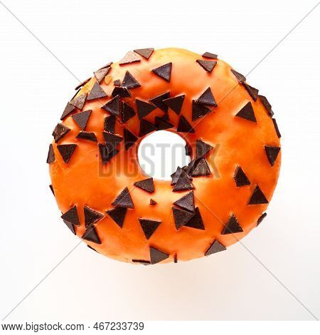 Halloween Donut With Orange Frosting And Chocolate Triangles As A Sweet Decorative Topping. Children