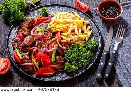 Lomo Saltado, Peruvian Dish Of Stir-fried Slices Of Beef Sirloin, Onions, Yellow Peruvian Chilis, An