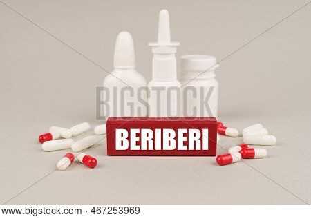 Medical Concept. On A Gray Surface Are Pills, White Jars And A Red Wooden Block With The Inscription