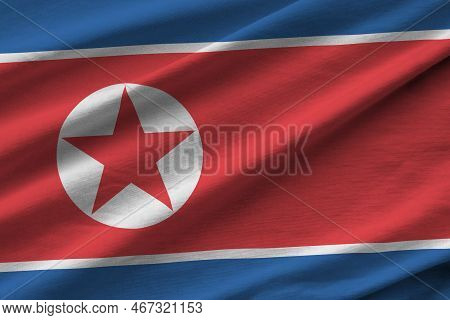 North Korea Flag With Big Folds Waving Close Up Under The Studio Light Indoors. The Official Symbols