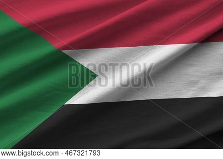 Sudan Flag With Big Folds Waving Close Up Under The Studio Light Indoors. The Official Symbols And C