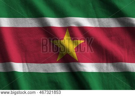 Suriname Flag With Big Folds Waving Close Up Under The Studio Light Indoors. The Official Symbols An