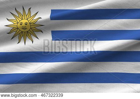 Uruguay Flag With Big Folds Waving Close Up Under The Studio Light Indoors. The Official Symbols And