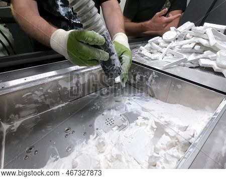 Male Worker Taking Out Models From White Polyamide Powder In Working Chamber Of 3d Printer, Cleaning