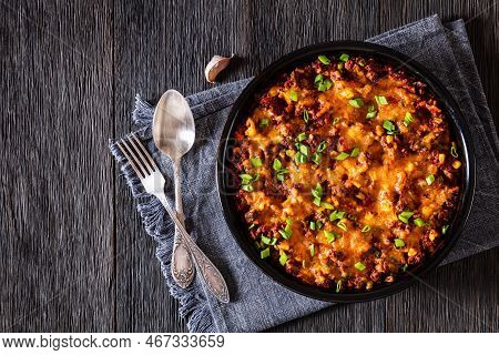Cajun Beef Cornbread Casserole Topped With Melted Red Cheddar Cheese And Scalions In Baking Dish On 