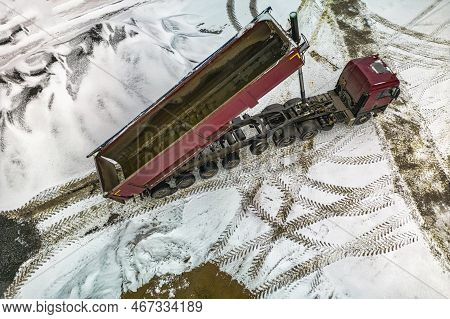 A Large Dump Truck Unloads Rubble Or Gravel At A Construction Site In Winter. Car Tonar For Transpor