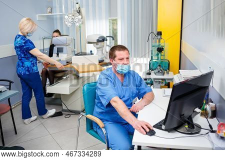 Ophthalmologist Consultation In A Modern New Hospital. A Modern Doctor Working With The Patient's He