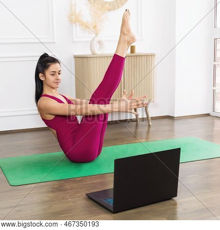 Young Beautiful Woman Leading A Healthy Lifestyle And Practicing Yoga, Watching Online Lessons And D