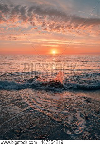 Sunrise On The Seashore On The Italian Riviera. Splashing Waves Illuminated By Sunlight. Vacation Tr