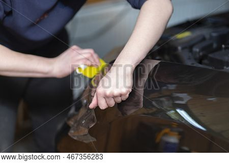 Installation Of A Protective Film On The Headlights Of The Car.car Body Protection.