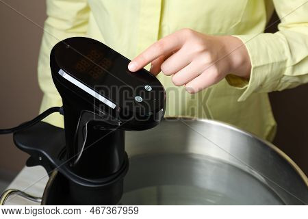 Sous Vide Cooking. Woman Using Thermal Immersion Circulator, Closeup