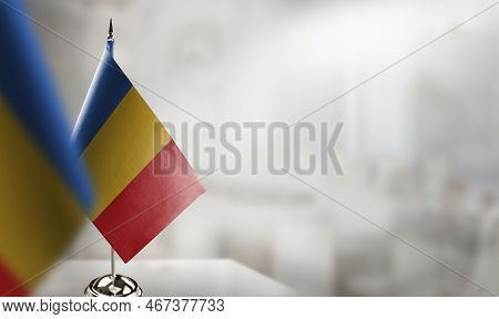 Small Flags Of The Chad On An Abstract Blurry Background.