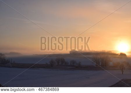 Orange Sunrise Above Snow Covered Eifel Landscape