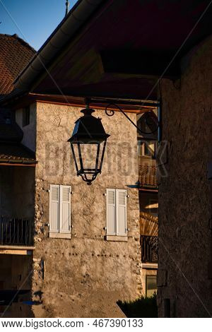 Talloires, France - September 08 2020 : A Lantern Is Hanging In Silhouette In An Old Medieval Small 