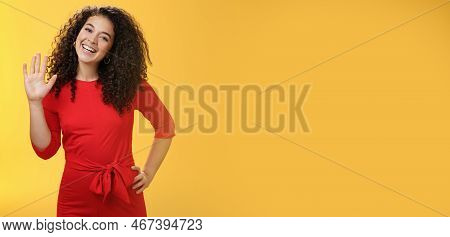 Hey My Name Is. Friendly-looking Self-assured Carefree Cute 25s Woman With Curly Hair Waving With Ra