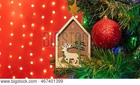 Christmas Decorations Hung On A Christmas Tree Against A Red Background.
