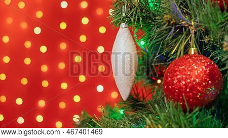 Christmas Decorations Hung On A Christmas Tree Against A Red Background.