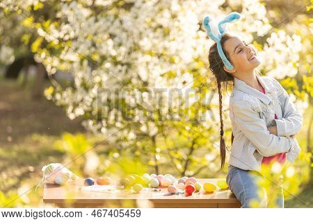 Teenage Girl Paints Easter Eggs In The Garden.