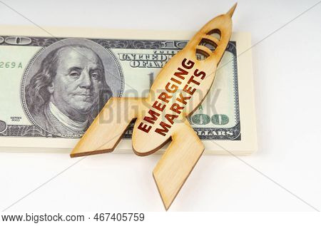 Business Concept. On The Dollars Lies A Wooden Model Of A Rocket With The Inscription - Emerging Mar