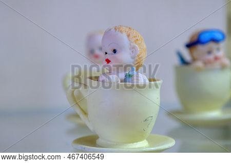 A Historical Porcelain Figurine. Porcelain Cup Little Porcelain Child With Glasses. Ancient Formatio