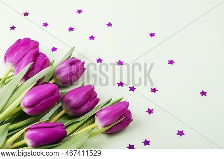 Bunch Of Purple Tulips And Star Confetti Background. Spring Holidays Concept. Top View.