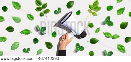Person Holding A Megaphone With Green Leaves - Flat Lay