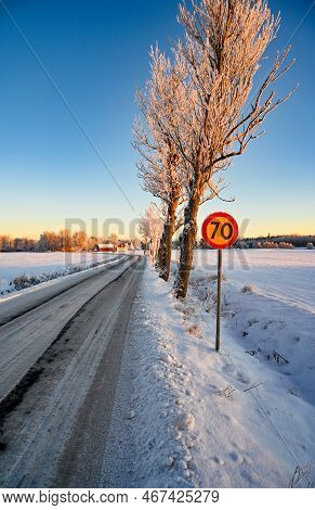 Icy Road Through Fields Covered In Snow
