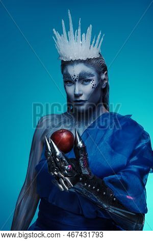 Ice Queen With Red Apple Against Blue Background