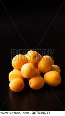 Apricots On A Black Background. A Handful Of Apricots On A Dark Background With Reflection. Useful S