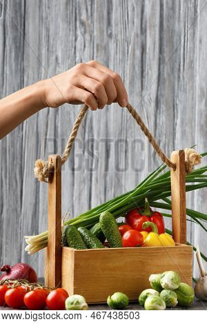 Tomatoes, Cucumbers, Peppers, Brussels Sprouts, Onions And Garlic In A Wooden Basket. Basket With Ve