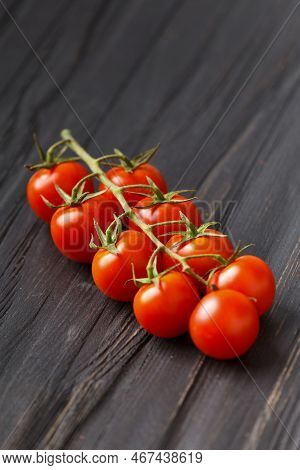 Cherry Tomatoes On A Branch On A Dark Background. Fresh Cherry Tomatoes On A Wooden Background. Heal