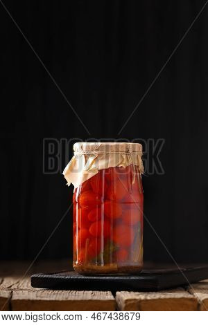 Canned Tomatoes. Pickled Tomatoes In A Jar. Sliced Tomatoes In A Marinade On A Wooden Background. To