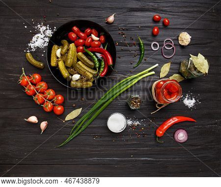 Assorted Pickled Vegetables. Canned Tomatoes, Cucumbers, Chili Peppers In A Round Black Plate On A D