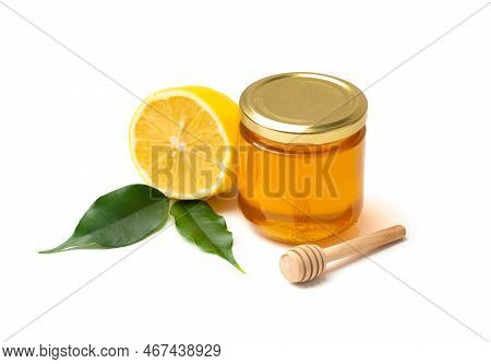 Honey In A Glass Jar And Lemon With Leaves On A White Background. Closed Jar With Honey And Honey St