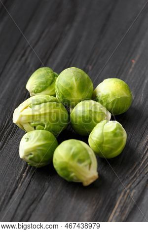 A Handful Of Brussels Sprouts On A Wooden Background. Fresh Cabbage On A Dark Background. Products F