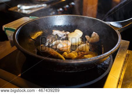 Cooking Prawns And Mussels By Frying In A Pan. Seafood, Healthy Vegetarian Food And Meal On A Dark B