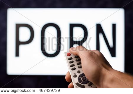 Young Man Having Watched A Ponography Film Pushes Red Power Button On A Remote Controller Of A Tv Se