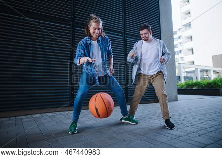 Man With Down Syndrome Playing Basketball Outdoor With His Friend. Concept Of Friendship And Integra