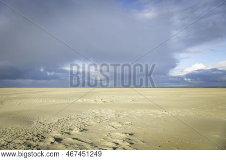 The Large Empty Beach On The Island Of Texel With The Horizon And Dark Clouds In The Background