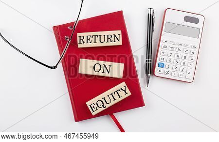 Return On Equity Text On A Wooden Block On Red Notebook