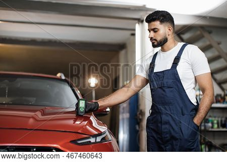 Young Attractive Man, Professional Service Specialist Testing Thickness Of The Car Paint In Protecti