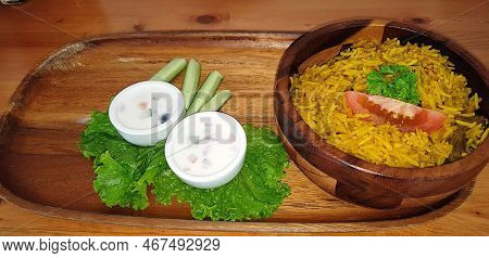 Rice Lamb Biryani Pilaf With Lamb Or Mutton Meat And Vegetables Cucumber Along With Yoghurt In A Ver