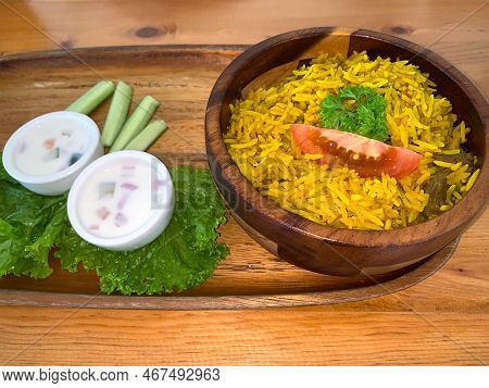 Rice Lamb Biryani Pilaf With Lamb Or Mutton Meat And Vegetables Cucumber Along With Yoghurt In A Ver