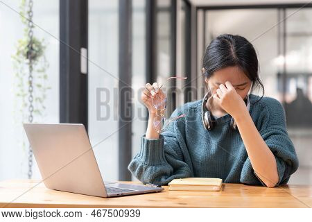 Shot Of Stressed Woman Working From Home On Laptop Looking Worried, Tired And Overwhelmed.