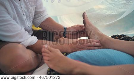 Male Masseur Massages The Legs In A Beautiful White Ornamrental Tent.