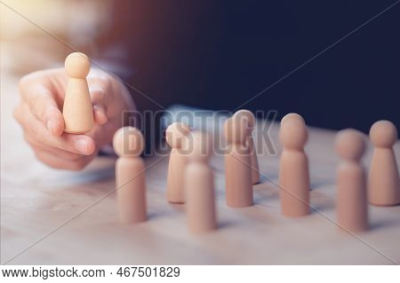 Hr Manager (human Resources) Or Employer Hand Choose Takes Person Wooden Doll. Leader Stands Out Fro