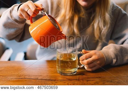 Portrait Of A Joyful Teengirl Enjoying A Cup Of Tea At Cafe. Smiling Beautiful Girl Drinks Hot Tea I