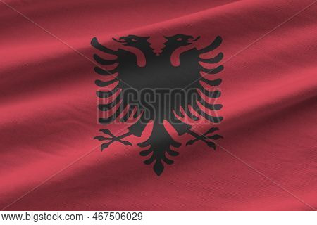 Albania Flag With Big Folds Waving Close Up Under The Studio Light Indoors. The Official Symbols And